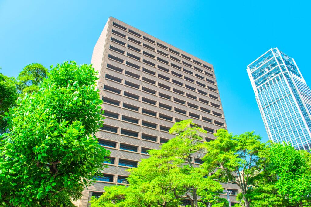 青空の下の緑の木々と高い建物