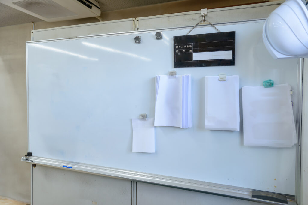 現場事務所のホワイトボードに貼った書類と標識