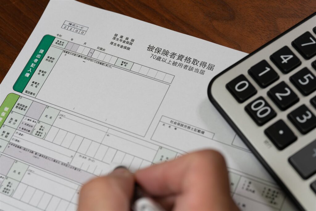 被保険者資格取得届に書き込む手元と電卓