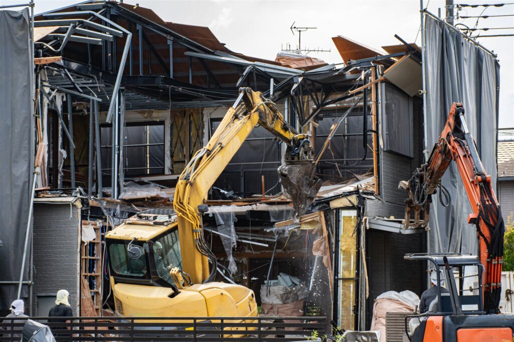 住宅地で重機が木造の建物を解体する現場