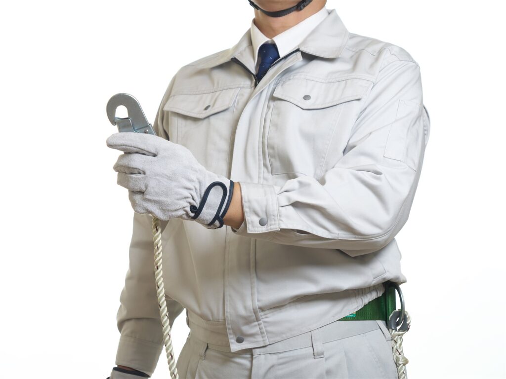 安全帯のフックとロープを持つ作業服の人