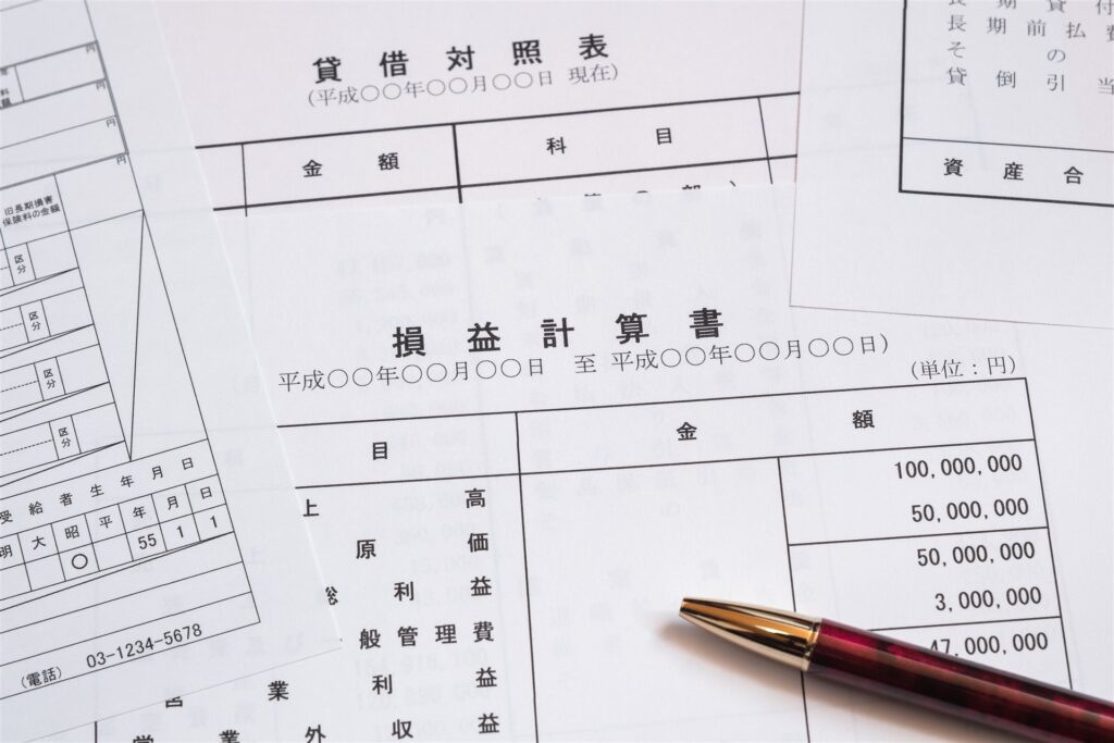貸借対照表と損益計算書の書類とペン
