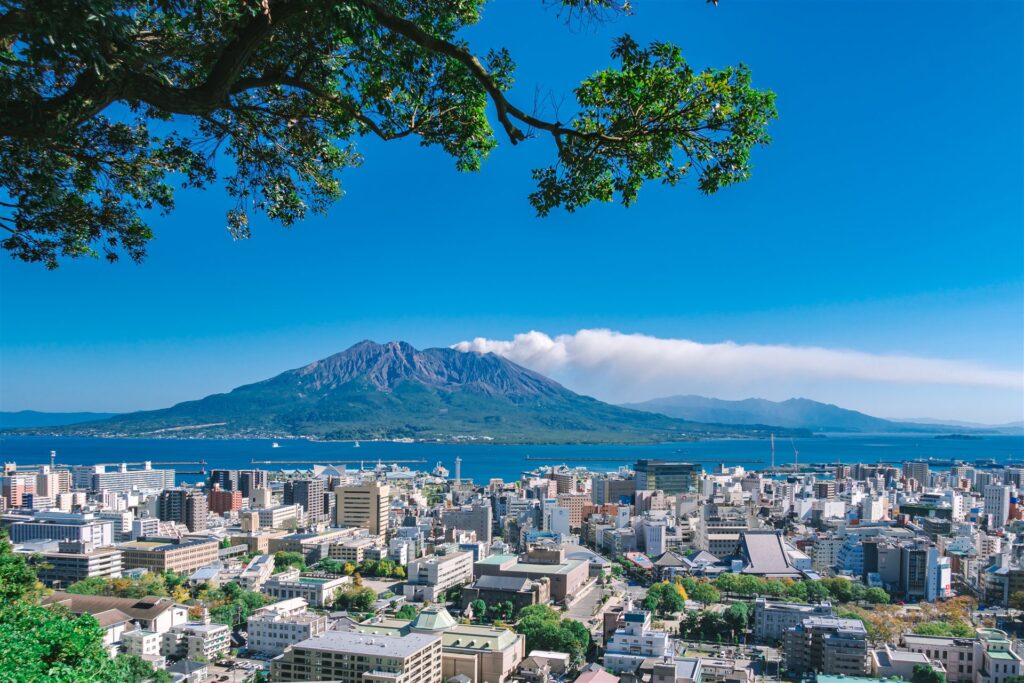 木々の間から見た鹿児島市の街並みと桜島