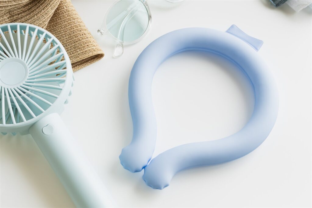 水色のネックリングと手持ちファン