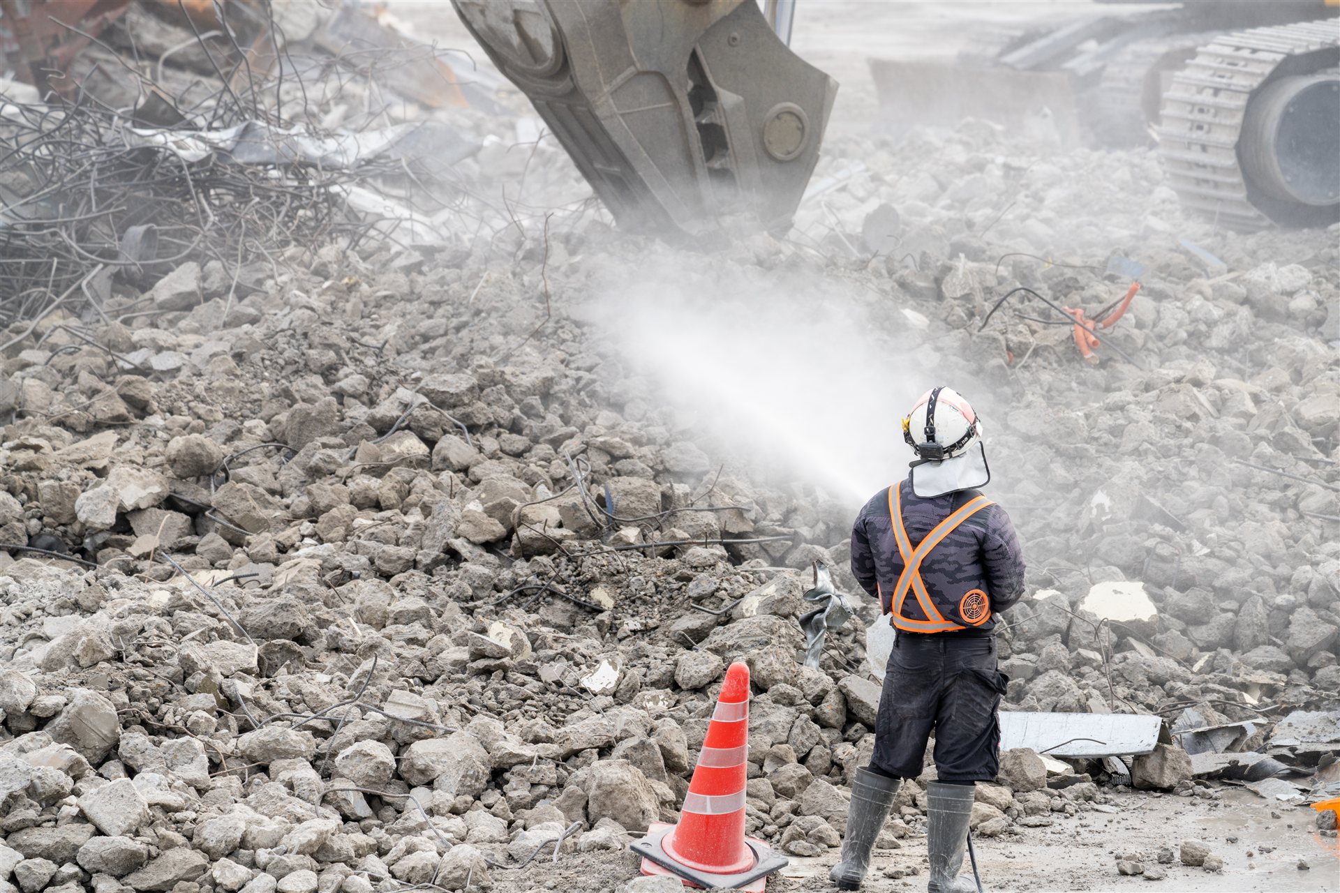 がれきに散水しながら進む建物の解体工事