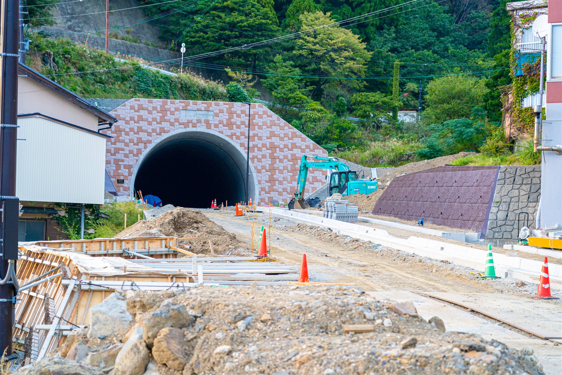 トンネルの入口と道路工事中の現場と重機