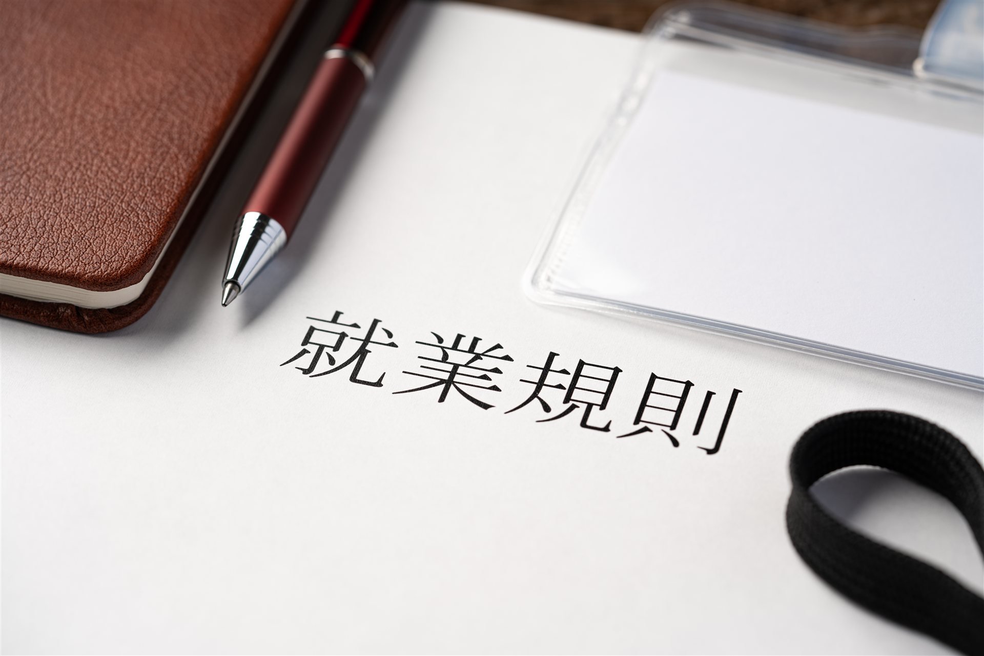「就業規則」と書かれた書類とペンと手帳