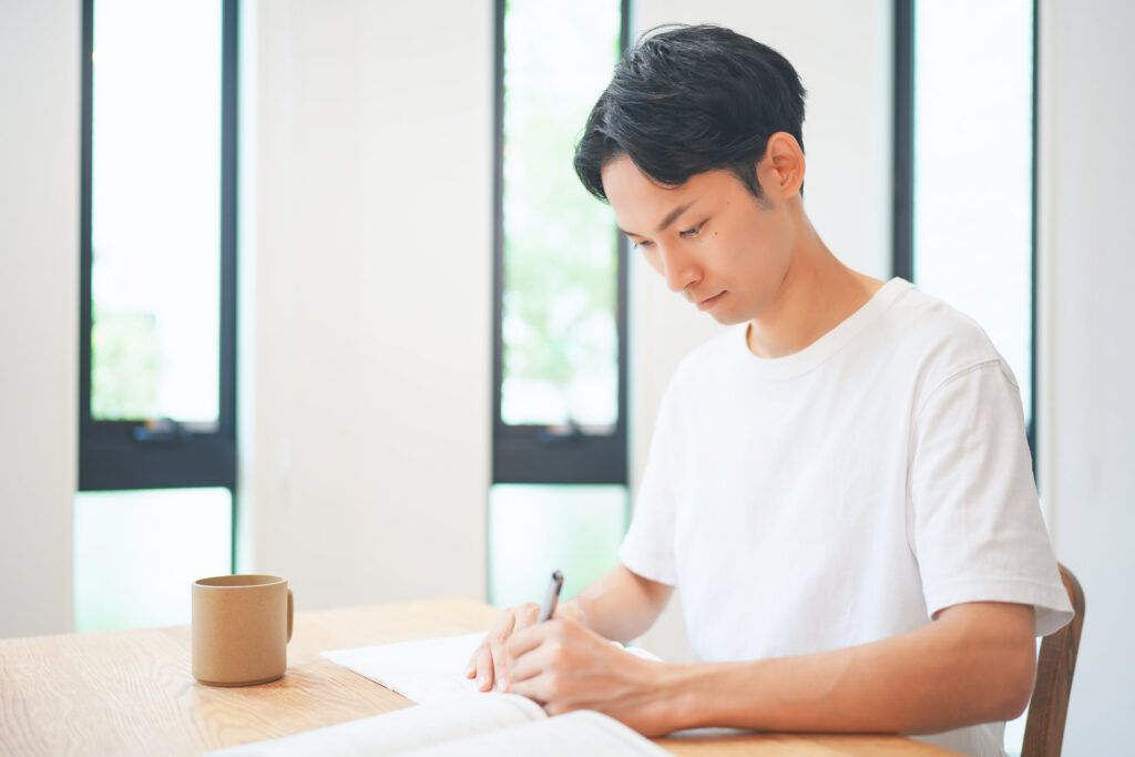 机に向かって資格試験の勉強をする男性