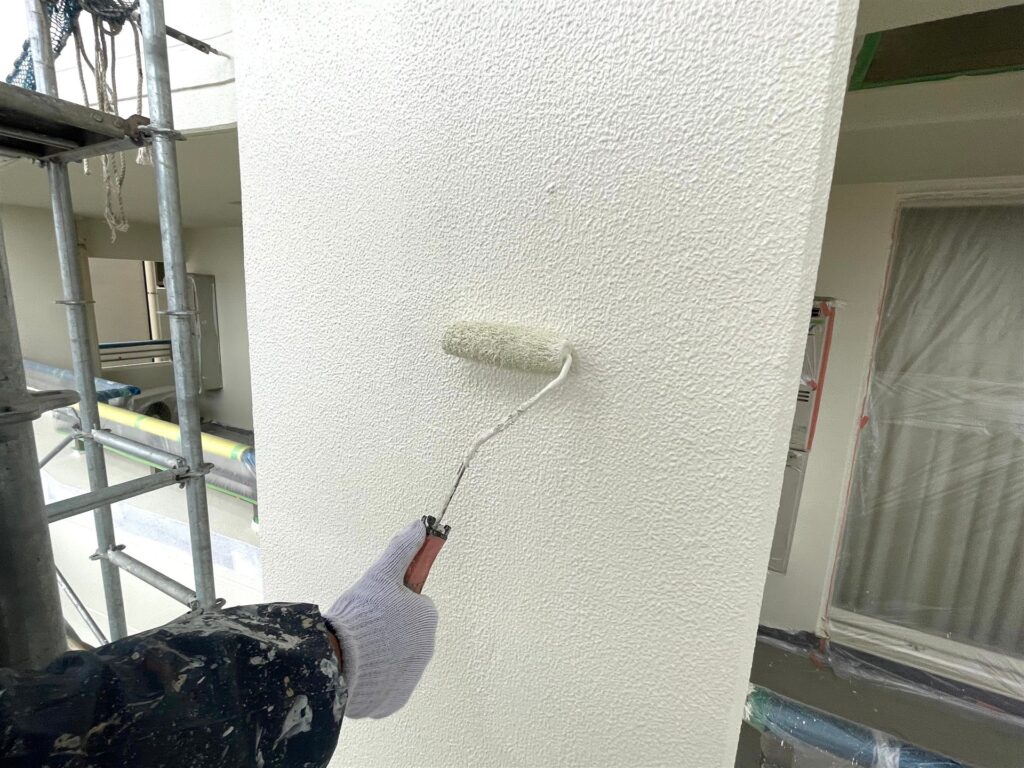 ローラーで外壁を塗装する職人の手元