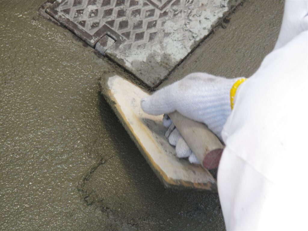 コテでセメントを打つ左官の手元