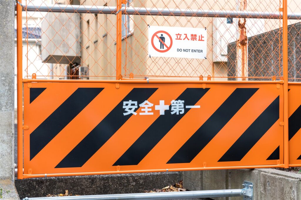 工事現場を囲うオレンジのガードフェンスと立入禁止の札