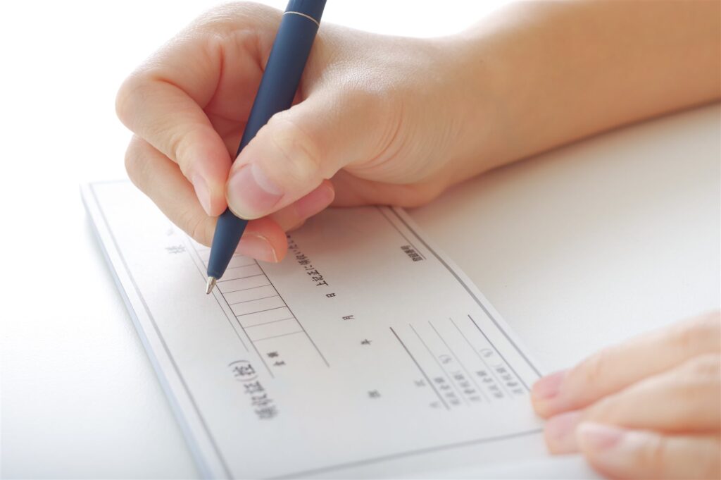領収証の用紙にペンで書き込む手元