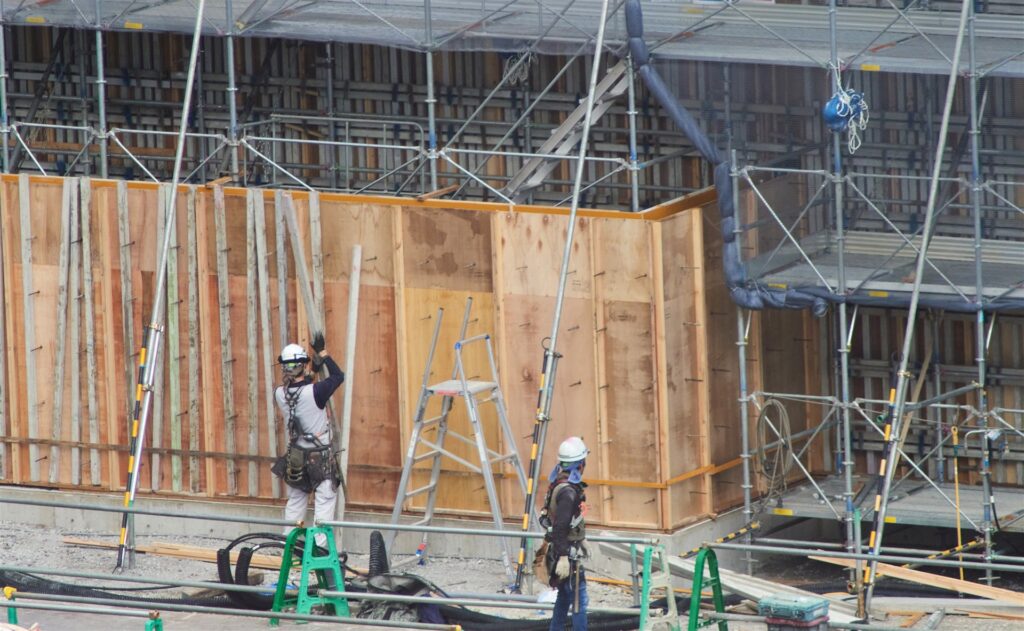 型枠と足場の前で働く作業員2人