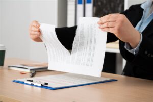 机の上で書類を破る手元