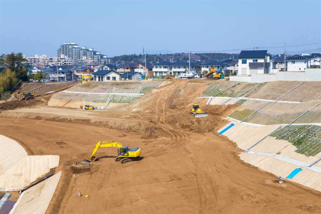 住宅地の横で進む大規模な宅地造成と重機