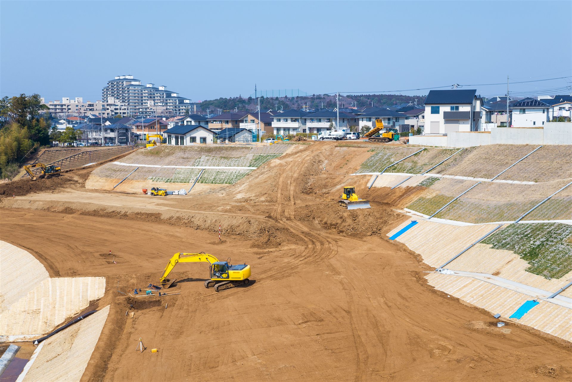 住宅地の横で進む大規模な宅地造成と重機
