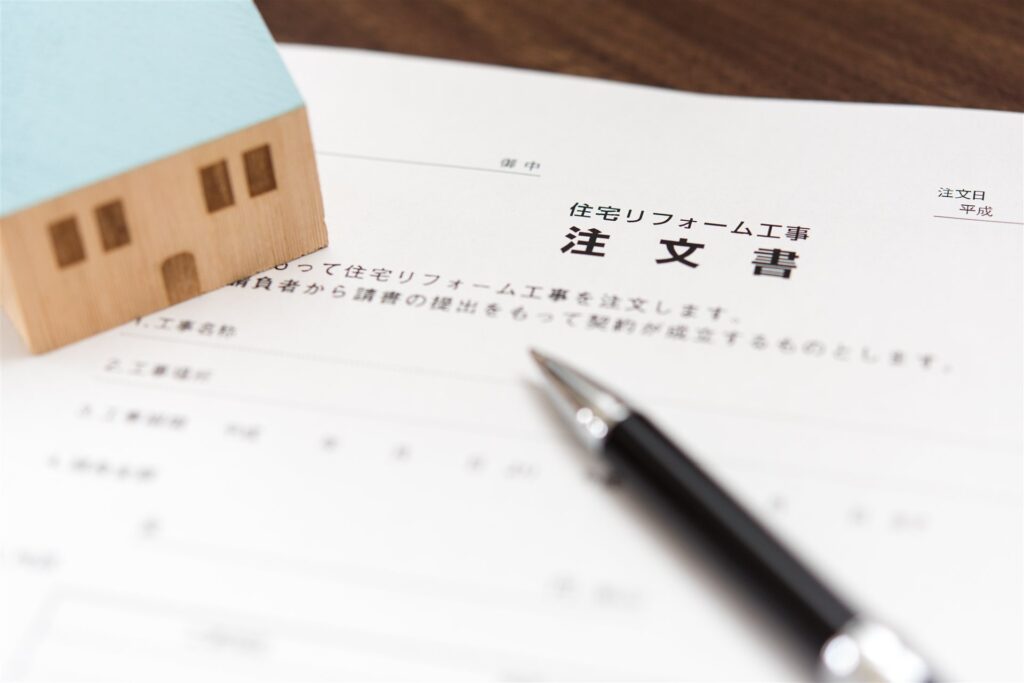 リフォーム工事の注文書とペンと家の模型