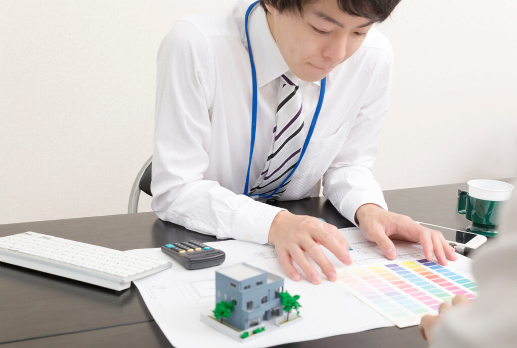 住宅の模型と色見本で提案を整理する担当者