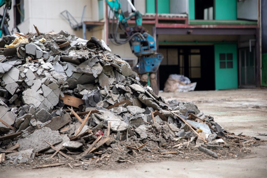 解体中の建物の前に積まれたがれきの山