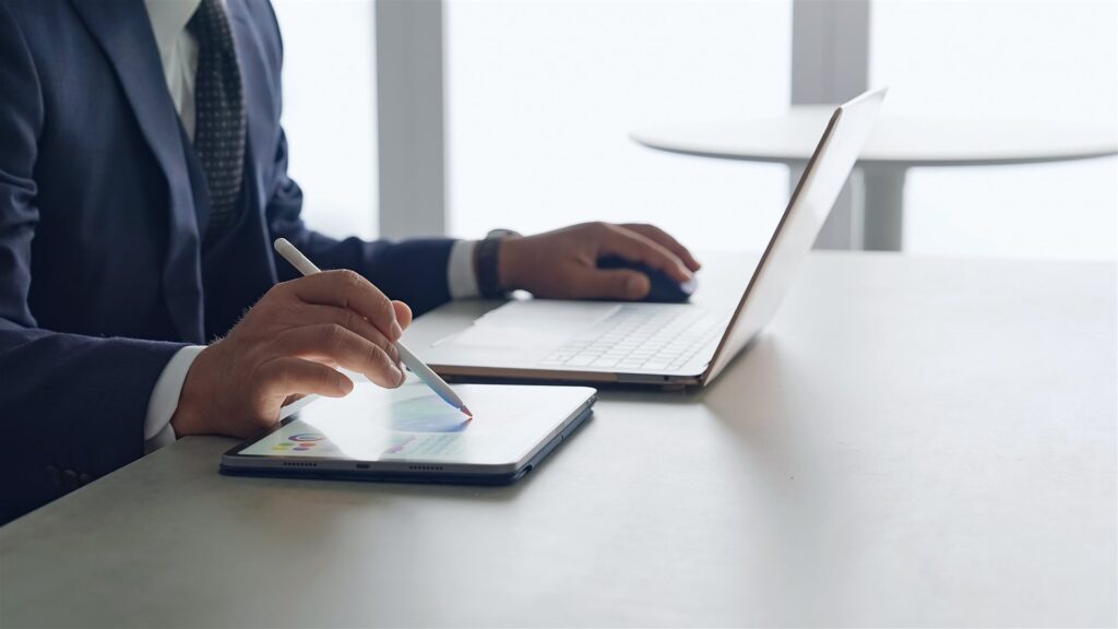 ペンでタブレットに書く手とノートパソコン