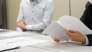 打ち合わせの机で書類をめくって確かめる手元