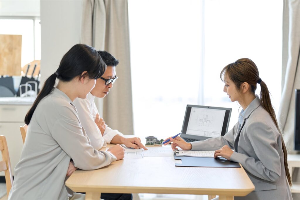 夫婦が間取りの図面を見ながら担当者と話す様子